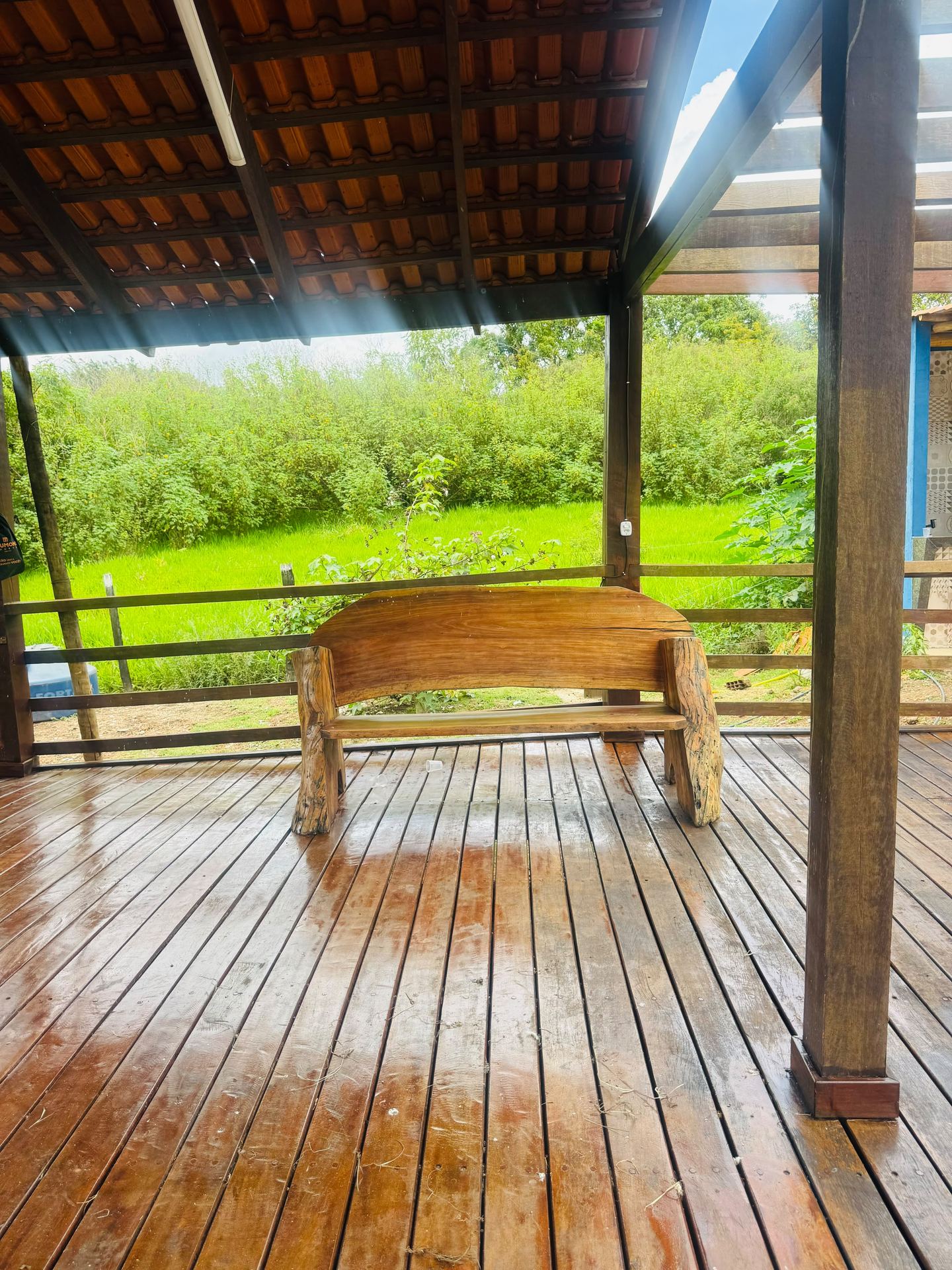 Deck de madeira com banco e vista para o verde