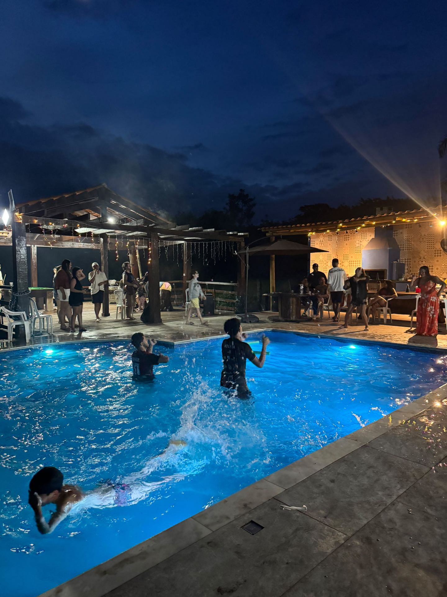 Piscina ao entardecer, com o campo ao fundo